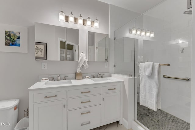 full bathroom with a tile shower, double vanity, and a sink