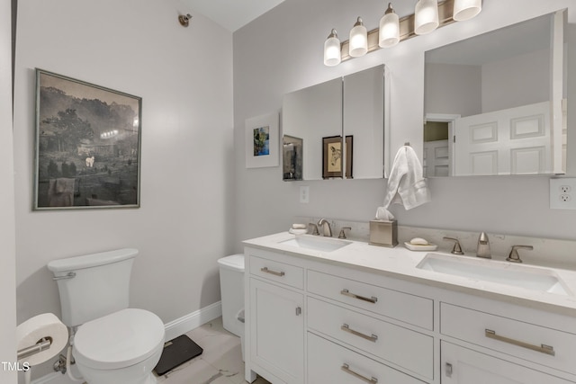 bathroom featuring toilet, marble finish floor, baseboards, and a sink