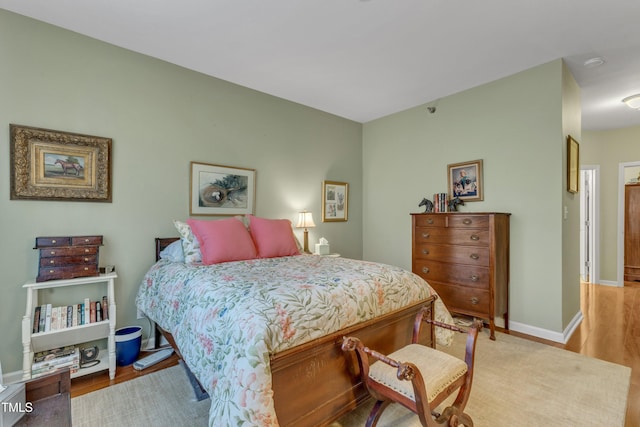 bedroom with baseboards and wood finished floors