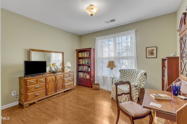 home office featuring light wood-style flooring, visible vents, and baseboards