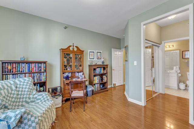 sitting room featuring baseboards and light wood-style floors