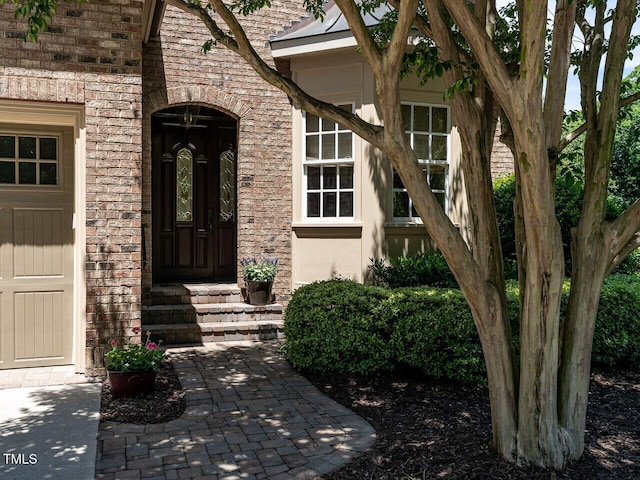 view of exterior entry featuring brick siding
