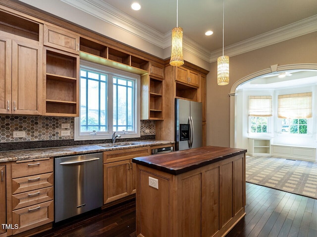kitchen with stainless steel appliances, open shelves, a sink, a kitchen island, and ornamental molding