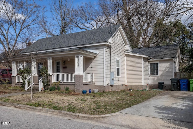 view of front of house with a porch, crawl space, a shingled roof, and fence