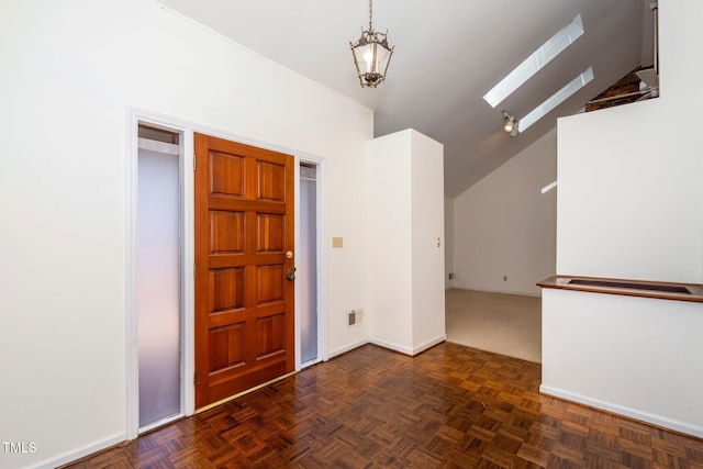 entrance foyer featuring vaulted ceiling with skylight, visible vents, and baseboards