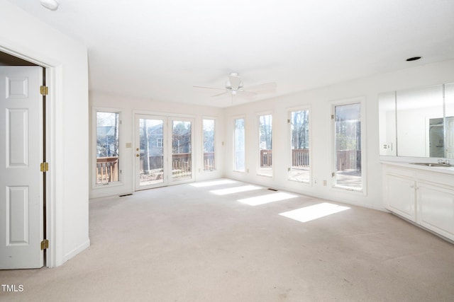 unfurnished sunroom with ceiling fan, visible vents, and a sink