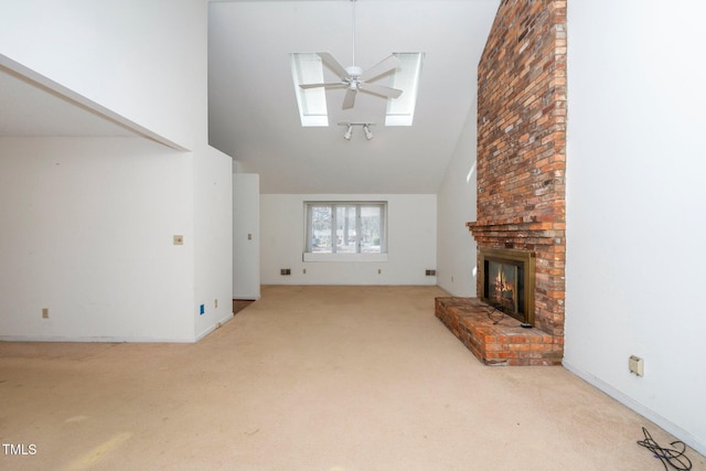 unfurnished living room with carpet floors, a fireplace, high vaulted ceiling, and ceiling fan