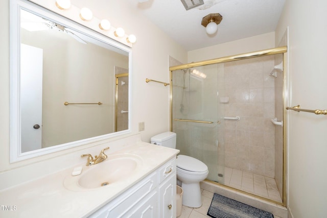 full bathroom featuring tile patterned flooring, a shower stall, toilet, and vanity