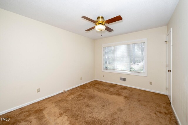 unfurnished room with ceiling fan, carpet floors, visible vents, and baseboards