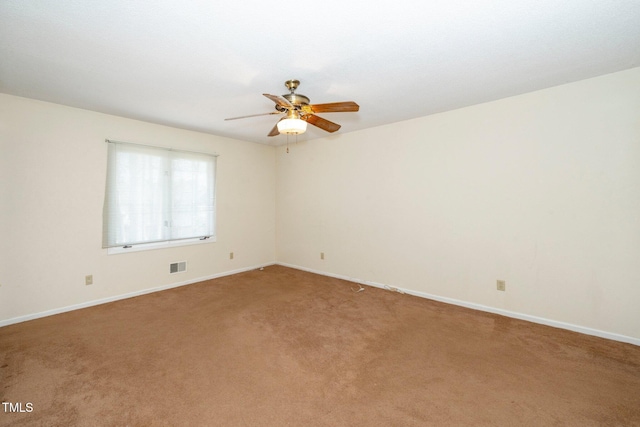 spare room with a ceiling fan, light colored carpet, visible vents, and baseboards