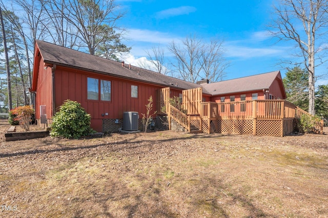 back of house with a deck, central AC unit, crawl space, board and batten siding, and a chimney