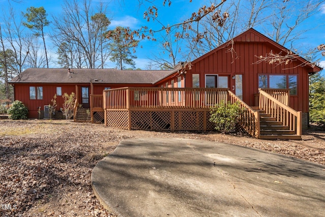 view of front of home with a shingled roof, central AC unit, a deck, and board and batten siding