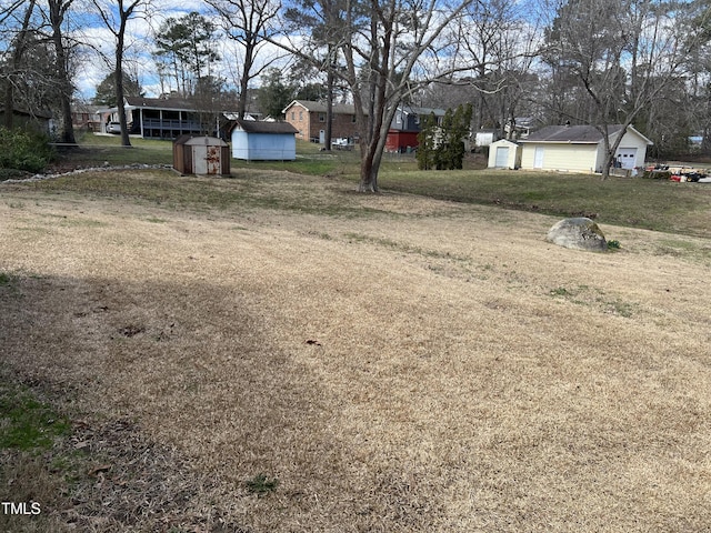 view of yard with a storage shed, a detached garage, and an outdoor structure