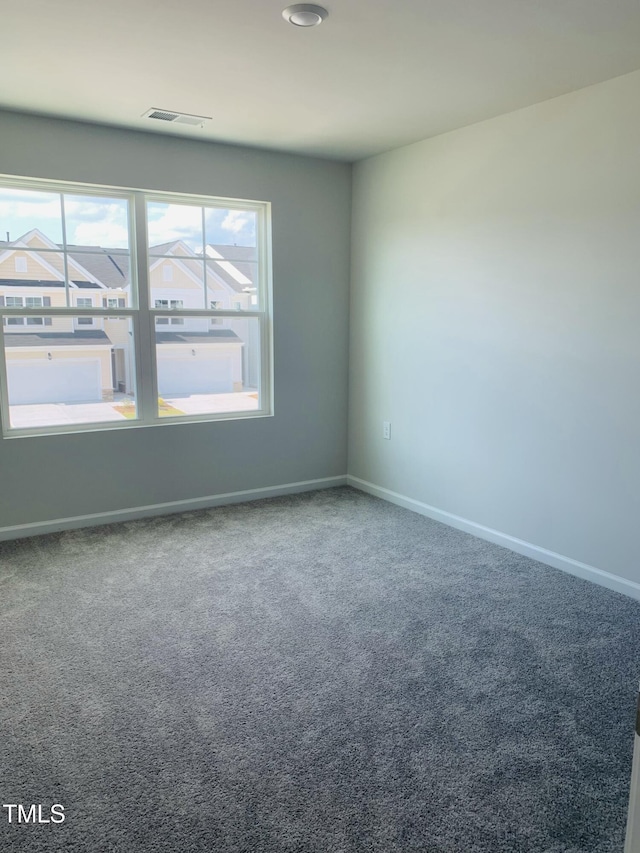 carpeted empty room with visible vents and baseboards