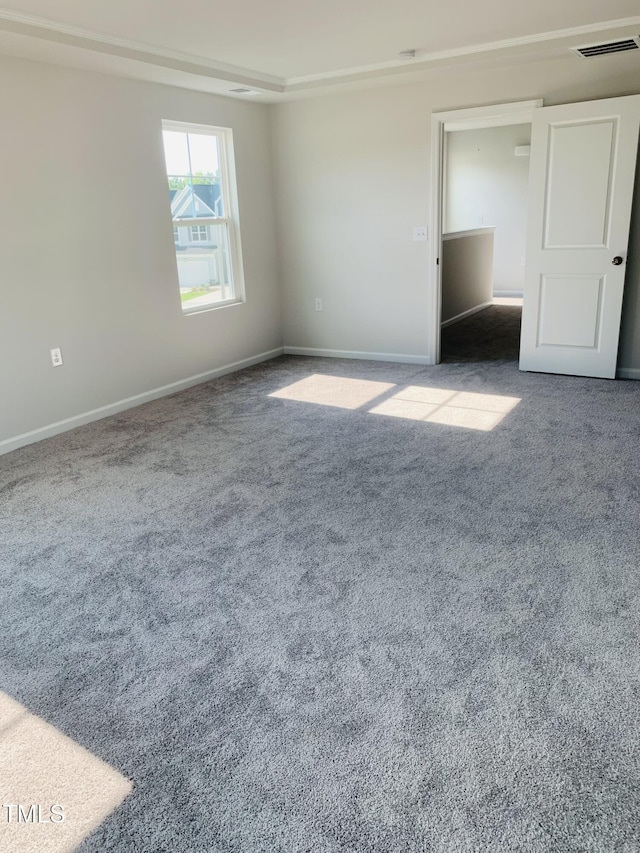 spare room featuring carpet, visible vents, and baseboards