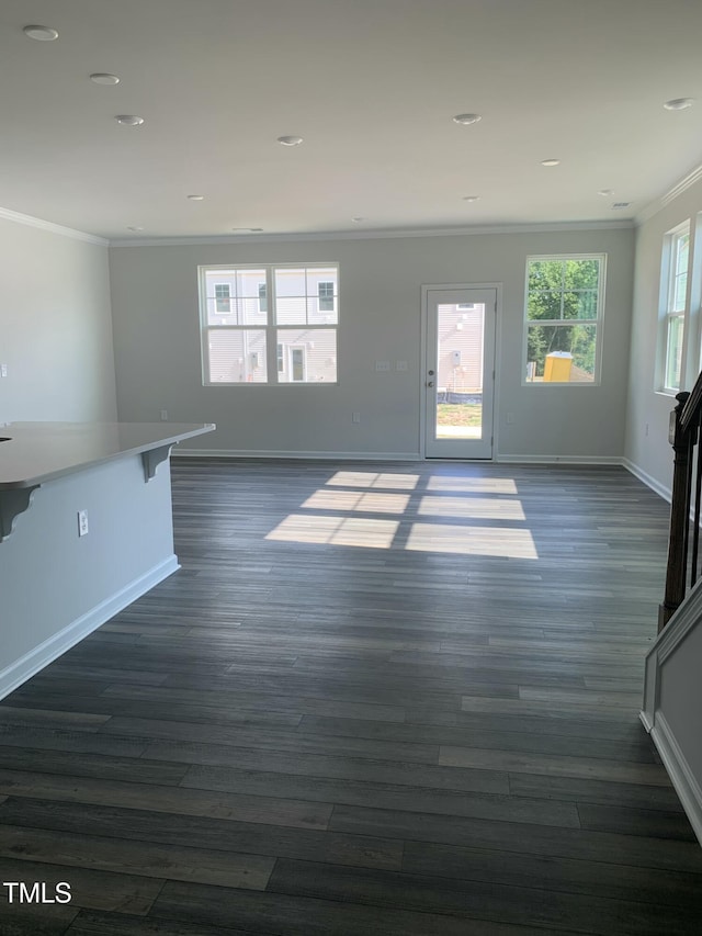 unfurnished living room with dark wood-style flooring, crown molding, and baseboards