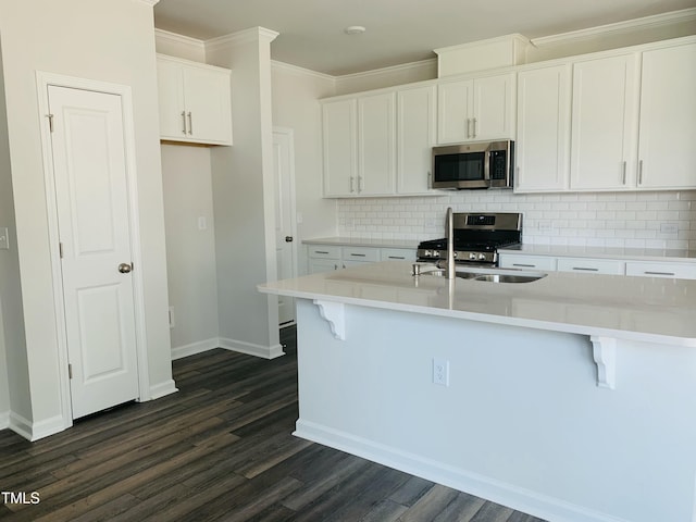 kitchen with white cabinets, decorative backsplash, ornamental molding, dark wood-style flooring, and stainless steel appliances