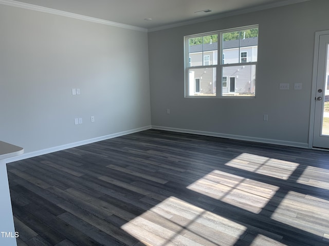 empty room featuring dark wood-style floors, baseboards, visible vents, and crown molding