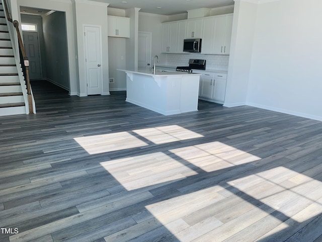 kitchen featuring dark wood-style floors, stainless steel appliances, tasteful backsplash, and white cabinets