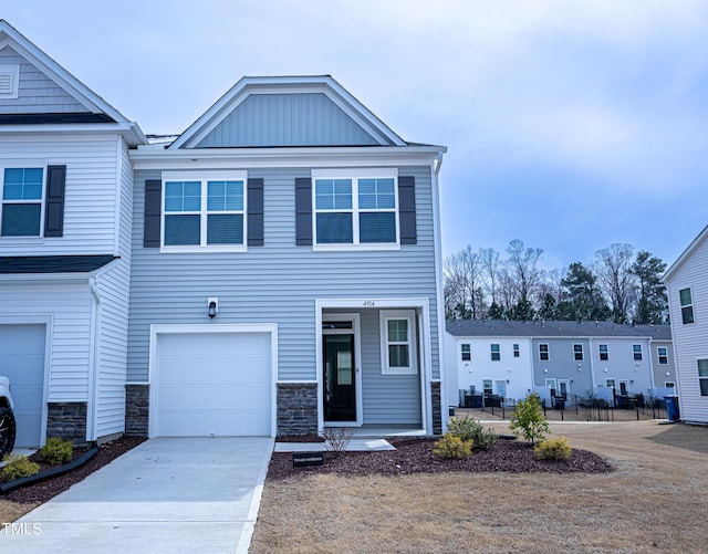 view of front of property featuring a garage, stone siding, board and batten siding, and concrete driveway