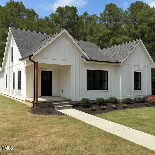 148 Mohawk Dr, Louisburg, NC 27549 - modern farmhouse featuring roof with shingles, covered porch, board and batten siding, and a front yard