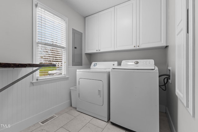 clothes washing area with electric panel, cabinet space, visible vents, and a wealth of natural light