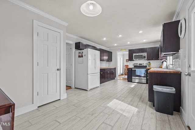 kitchen with wooden counters, a sink, dark brown cabinets, appliances with stainless steel finishes, and light wood-type flooring