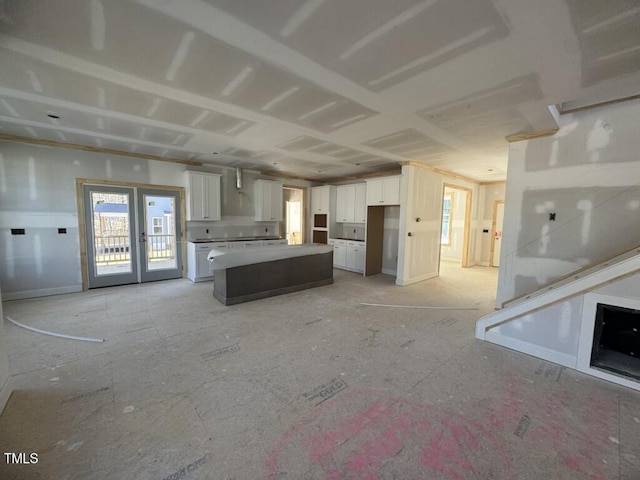 kitchen featuring open floor plan, french doors, a kitchen island, and white cabinets