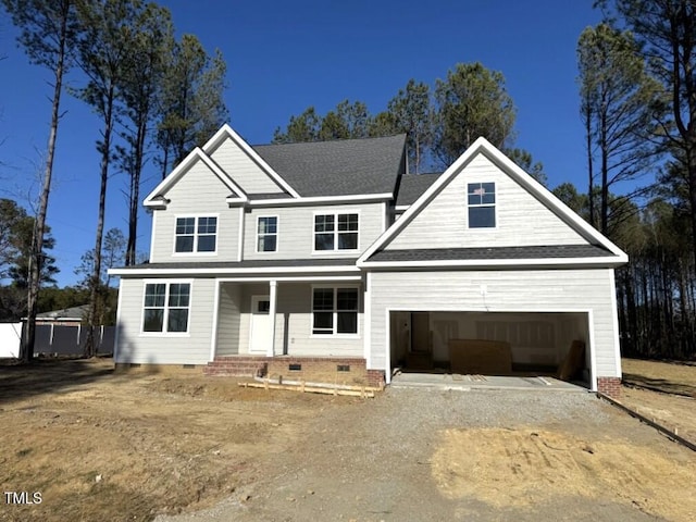 traditional-style home featuring an attached garage, covered porch, a shingled roof, dirt driveway, and crawl space