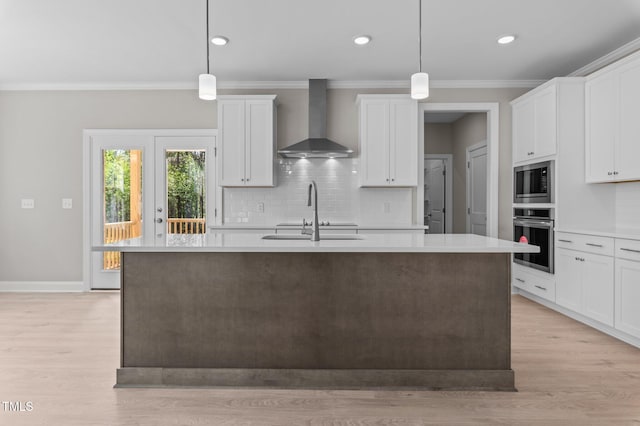 25 Arbor Dr, Youngsville, NC 27596 - kitchen with an island with sink, wall chimney exhaust hood, light countertops, a sink, and stainless steel appliances