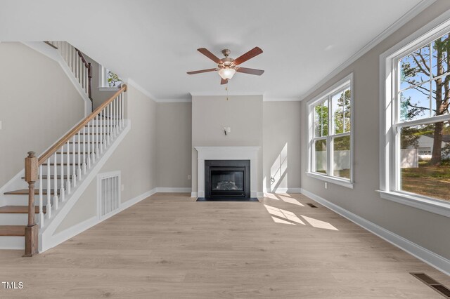 25 Arbor Dr, Youngsville, NC 27596 - unfurnished living room with ornamental molding, visible vents, ceiling fan, and stairway