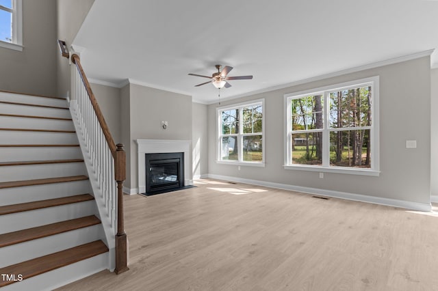 25 Arbor Dr, Youngsville, NC 27596 - unfurnished living room with ornamental molding, stairway, a ceiling fan, a fireplace with flush hearth, and visible vents