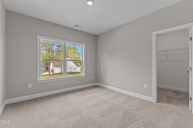 25 Arbor Dr, Youngsville, NC 27596 - unfurnished bedroom with a walk in closet, carpet, visible vents, and baseboards