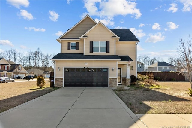 craftsman-style home featuring an attached garage, concrete driveway, stone siding, and fence