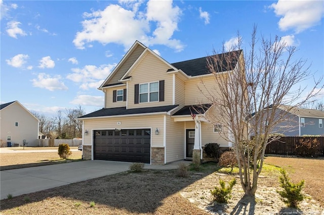 view of front of property with stone siding, concrete driveway, fence, and a garage