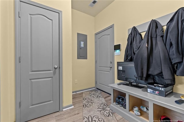 mudroom with visible vents, light wood finished floors, electric panel, and baseboards