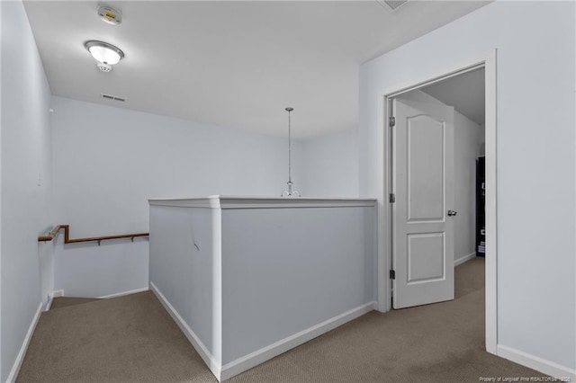 corridor featuring visible vents, carpet, an upstairs landing, and baseboards