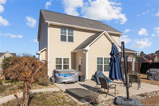 rear view of house with a gate, a patio area, and fence