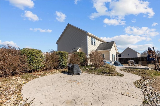 view of side of property with a patio area and fence