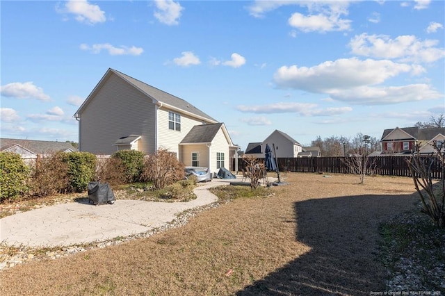 rear view of property featuring fence and a patio