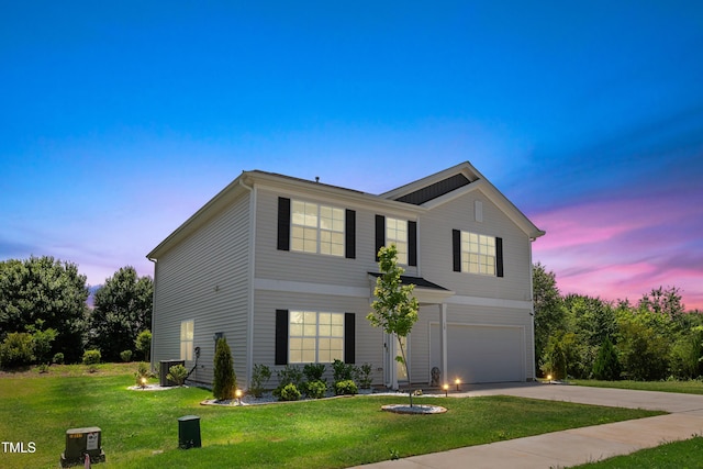 traditional home with a garage, driveway, and a front lawn