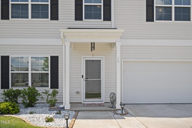 entrance to property with driveway and an attached garage