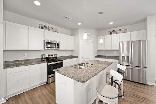 kitchen with stainless steel appliances, dark wood-style flooring, a sink, visible vents, and white cabinets