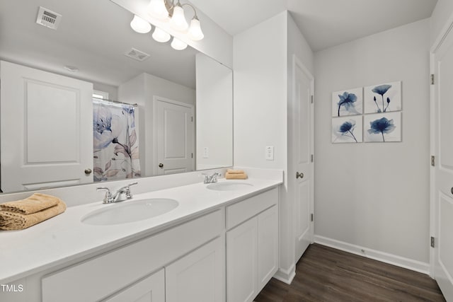 full bathroom featuring wood finished floors, a sink, and visible vents