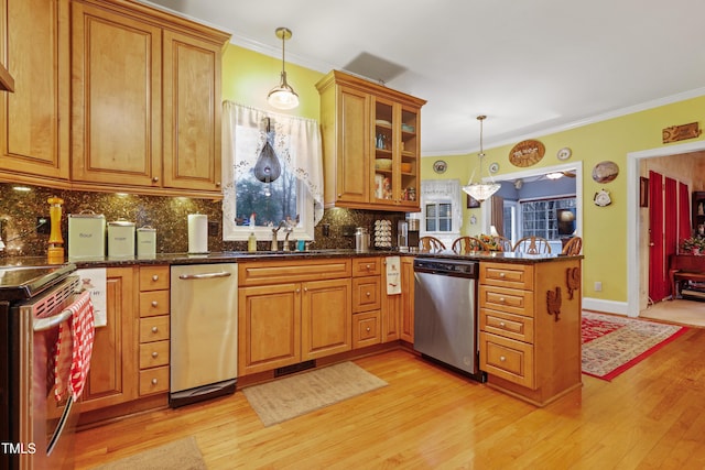 kitchen with crown molding, brown cabinets, a peninsula, stainless steel appliances, and a sink