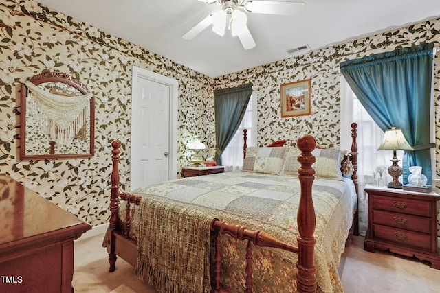 bedroom featuring wallpapered walls, a ceiling fan, visible vents, and carpet floors