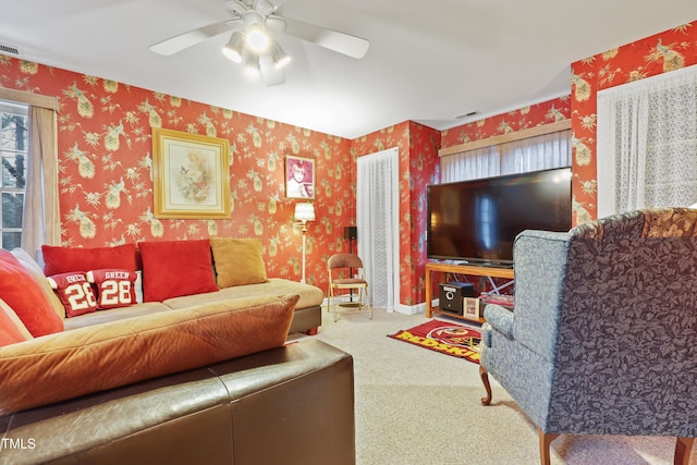 living room with wallpapered walls, carpet flooring, and visible vents