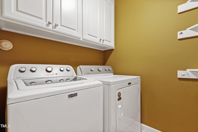 clothes washing area with cabinet space and washer and clothes dryer