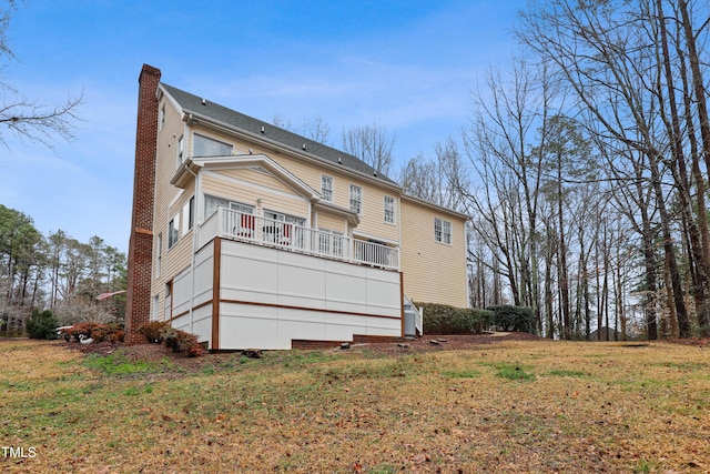 back of property featuring a lawn and a chimney