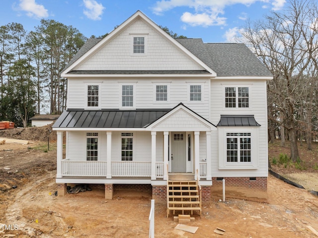 view of front of house with roof with shingles, covered porch, metal roof, crawl space, and a standing seam roof